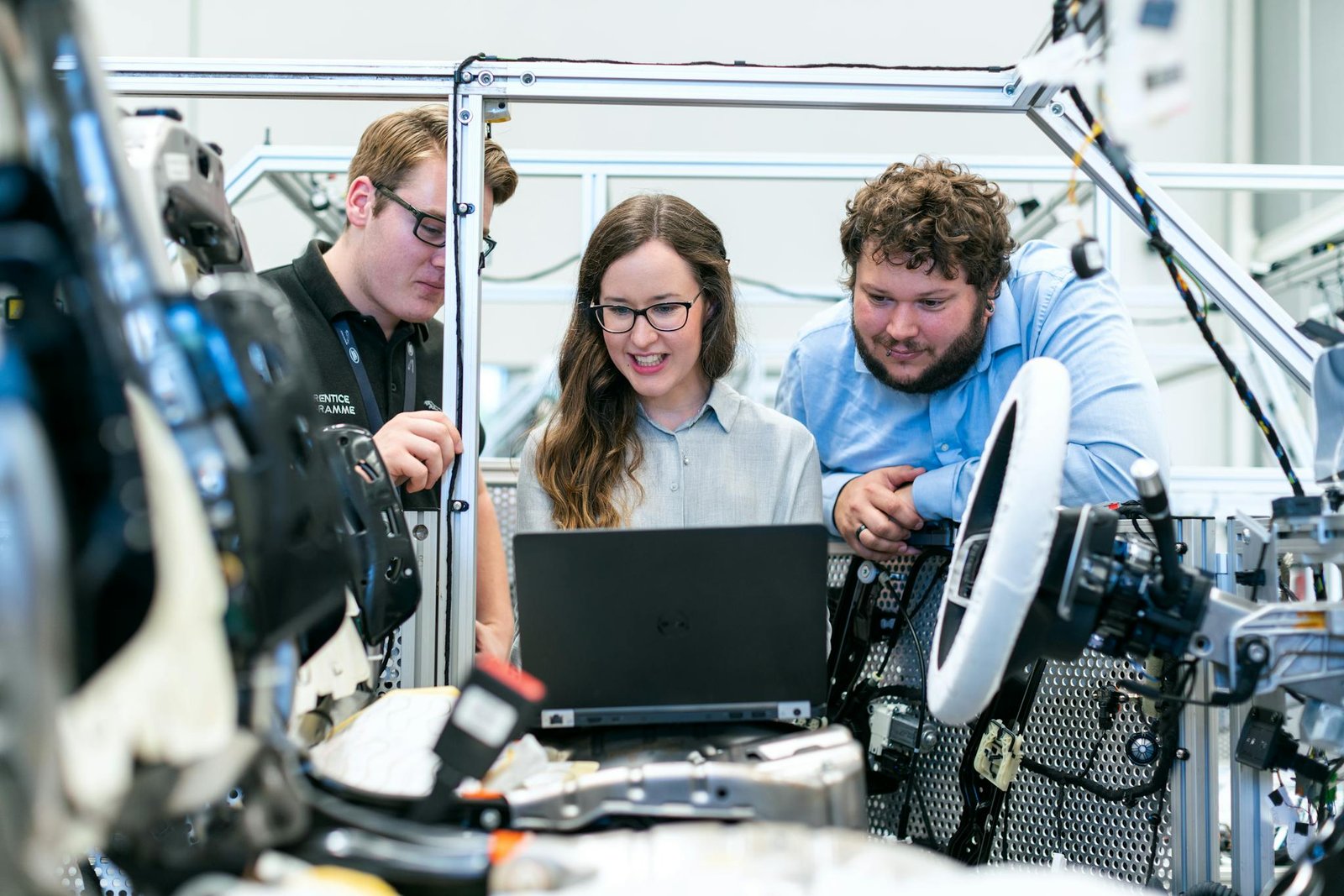 Home Engineers collaborating on a car project in a modern automotive workshop using advanced technology.